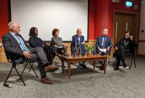 Image showing three men and three women sitting in front of a low coffee table in a lecture theatre