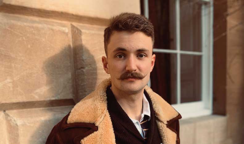A man with short dark hair and a moustache