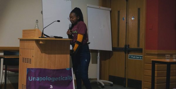 Patricia Mativo speaking on a podium.