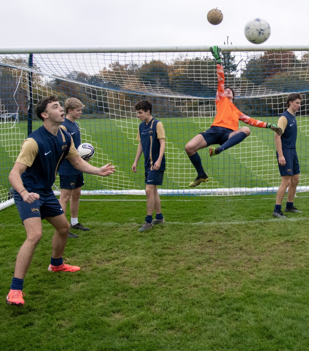 Oriel men's football team playing with a ball around a football post