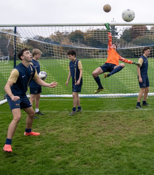 Oriel men's football team playing with a ball around a football post