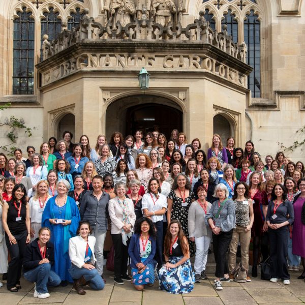 A group of women posing in front of the steps of the First Quad of Oriel College