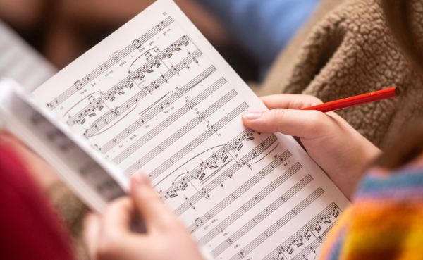 Page of sheet music held by an Oriel student