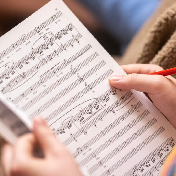 Page of sheet music held by an Oriel student