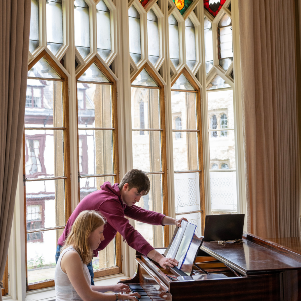 Students playing piano in the Music Room at Oriel College